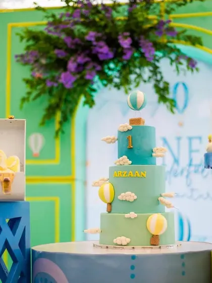 The beautiful, multi-tiered hot air balloon cake, decorated with fluffy clouds and miniature balloons, ready for the celebration.
