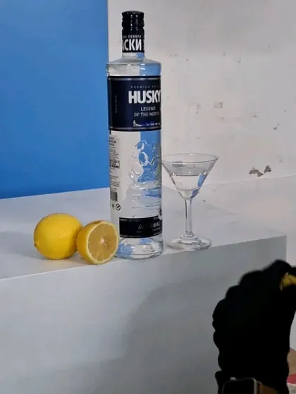 The simple, clean setup for the Husky Vodka shot with a bright blue background.