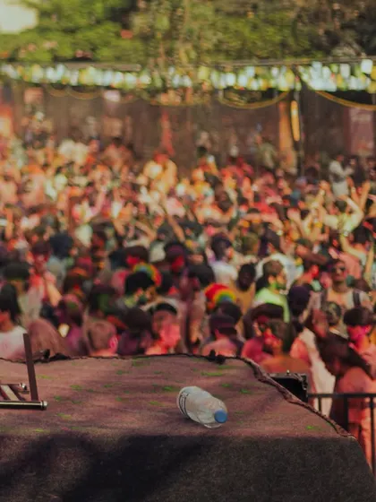The aftermath of a massive Holi set. An empty water bottle on a stage covered in color.
