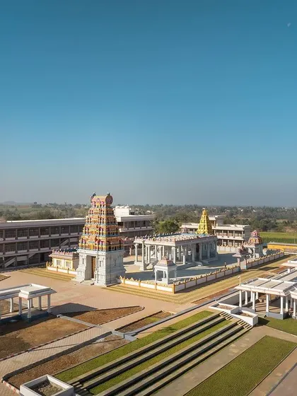 A wide view of the Shiva Temple complex, showcasing the main Gopuram and the expansive courtyard. The design balances the grandeur of traditional temple architecture with serene, open areas for congregation and reflection.