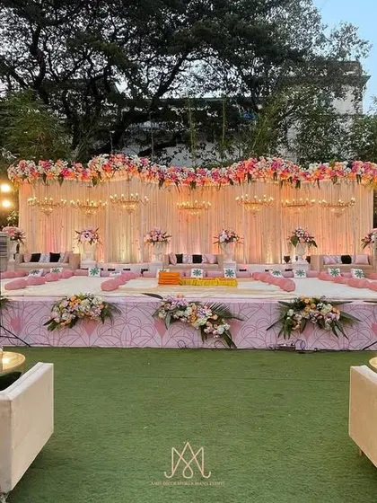A wide view of a beautiful Mamera event, with a pink floral stage, elegant lounge seating, and traditional low seating arrangements for the ceremony.