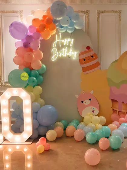 Scoops of fun for a 10th birthday! This ice cream-themed party decor features a pastel balloon arch, a giant ice cream cone prop, and cute character cutouts for a sweet celebration.