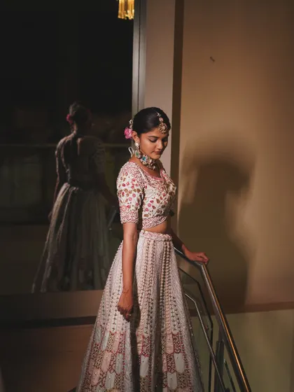 Golden hour glow, but make it bridal. This shot captures the bride's elegance and the beautiful details of her lehenga and floral bun.