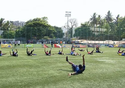 Athletes performing dynamic core and mobility exercises on the field. This is a crucial part of our warm-up protocol to prepare the body for the high-intensity demands of a football training session.
