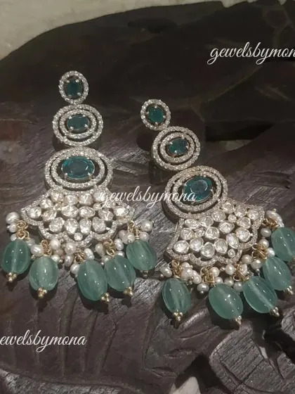 A closer look at the stunning polki and green bead chandelier earrings. The intricate setting of the polki stones and the cascading beads create a look of pure luxury.