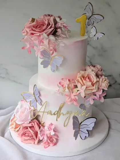 Celebrating Aadhyaa's first trip around the sun with this beautiful floral and butterfly cake. The two-tier design features a soft pink watercolor effect, fresh roses, and delicate butterflies.