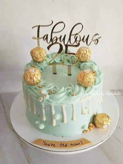 "Fabulous 25" is the theme for this fun and stylish no-fondant cake. A mint green drip cake is topped with Ferrero Rocher chocolates and a custom topper to welcome a milestone birthday.