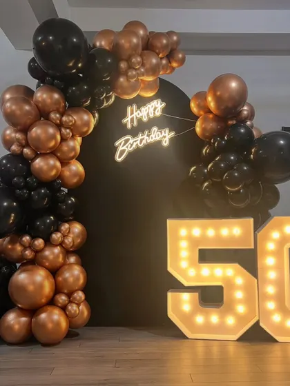 A clear, centered photograph of the milestone decor. This classic black and gold theme is highly requested for its timeless and celebratory look, suitable for both personal parties and corporate functions.
