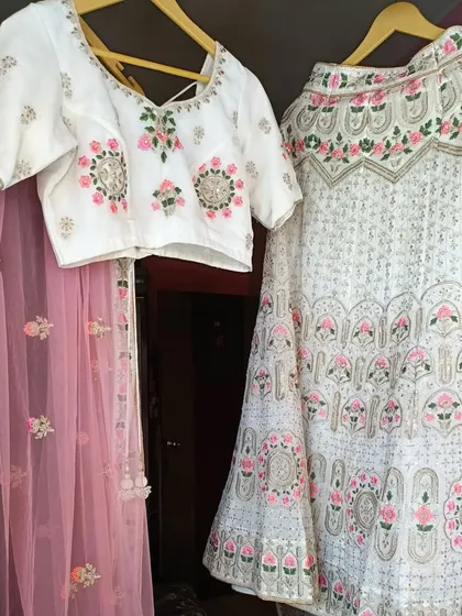 The complete white floral lehenga set, including the blouse, skirt, and matching pink dupatta. A perfect rental for a day event.