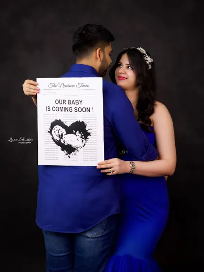 A fun and creative announcement photo. The couple holds a custom newspaper sharing their happy news, with their faces hidden in a playful way.