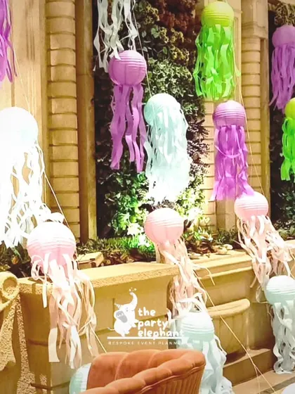 More jellyfish lanterns arranged against a green wall, showing how we can transform any space, indoors or out, into a magical ocean scene.