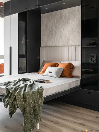 Here you can see the Murphy bed in the down position. The design includes a comfortable upholstered headboard and a textured accent wall, making the space feel cozy even with its minimalist palette.