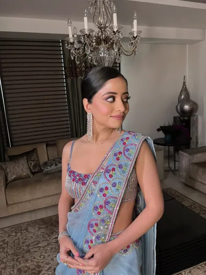 A side profile capturing the elegance of the sleek ponytail and the subtle glow of the makeup.