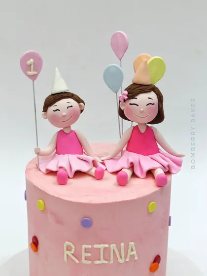A lovely cake for a first birthday, topped with two adorable twin girl figurines. I teach how to create matching but unique characters to celebrate special bonds.