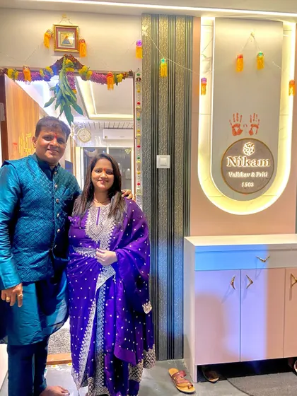 The happy Nikam family at the entrance of their newly designed 1BHK home in Kurla, featuring a custom nameplate.