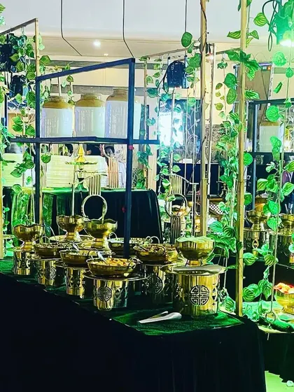 A salad bar setup with a focus on quality and aesthetics. The green and gold theme, with lush ivy and brass serving dishes, creates a fresh and luxurious feel.