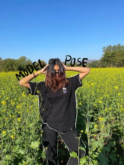 A model pose in a field of yellow flowers, with a simple text doodle.
