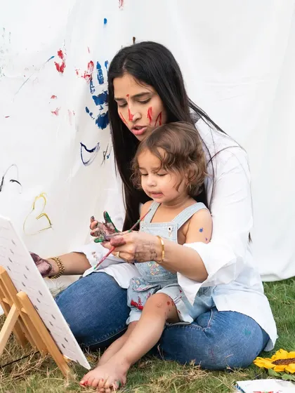 A mother and daughter painting together during an outdoor session. Shared activities create natural opportunities for beautiful, candid photos that tell a story.
