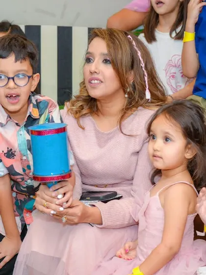 A mother and her children watch the party entertainment with rapt attention.