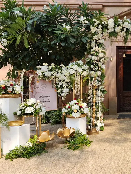 A beautiful entrance setup with an arch of white flowers and hanging pearl strings, creating a look of timeless elegance.