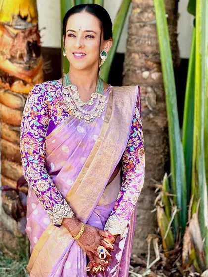 Our client Bindu looks stunning in a lavender silk saree paired with a custom full-sleeve blouse. The blouse is covered in a vibrant, multi-colored floral embroidery, showcasing her eye for detail and love for unique designs.