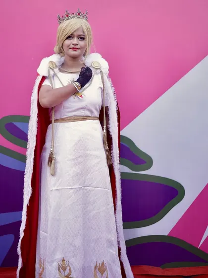 A cosplayer dressed as a royal character poses against a colorful wall. I am always looking for great backdrops to make the subjects stand out.