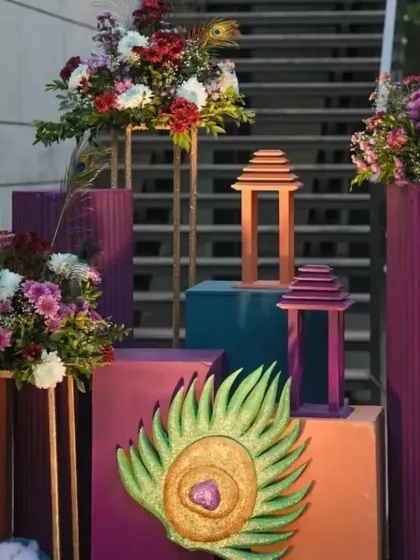 Decorative details from a Krishna party, including peacock feather motifs, floral arrangements, and traditional lanterns.