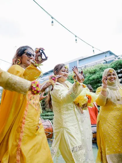 The women of the family dance together, celebrating the bride-to-be with energy and joy.