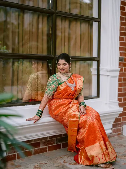 A quiet moment for the bride, Prerna, seated by a window, her reflection adding depth to the portrait.