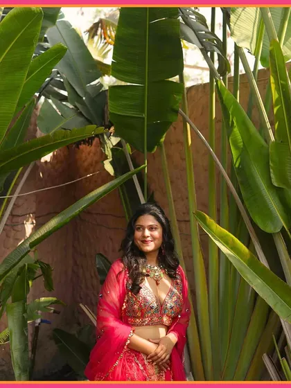 A beautiful shot of the bride amidst lush greenery, her Mehendi look a masterpiece of elegance and charm.