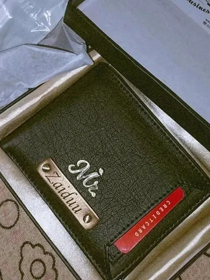 This personalized black wallet features a unique design with an external card slot in red, customized with a 'Mr.' charm and nameplate.