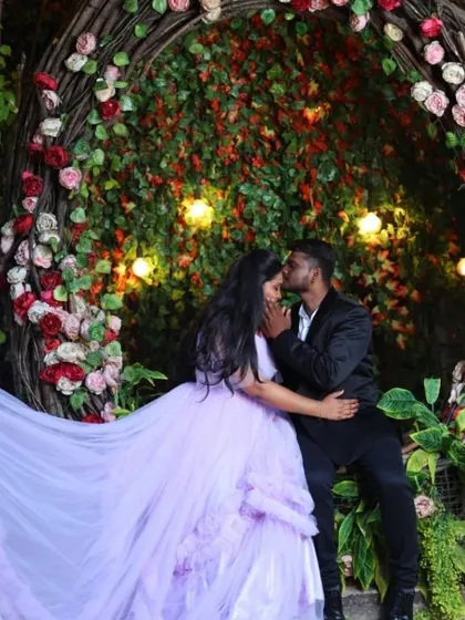 A tender moment captured during their pre-wedding shoot. The soft lavender gown and the floral backdrop create a truly magical and romantic atmosphere.