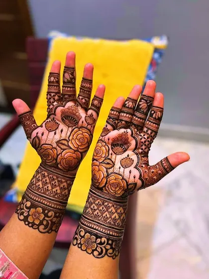 This design features beautiful rose motifs covering the hands, with a delicate net pattern on the palms. It's a romantic and popular choice for engagements and anniversaries.