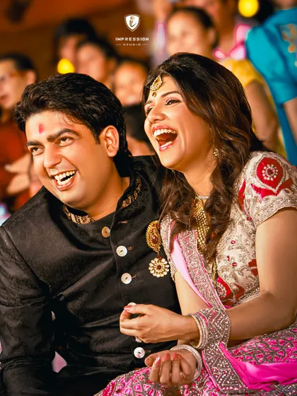 That shared laugh that says it all. This candid shot captures the beautiful chemistry and happiness of the couple during their wedding festivities.
