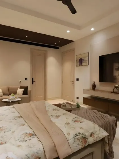 A view from the bed, showing the floating TV unit and the seamless integration of storage and display elements in this timeless master bedroom.