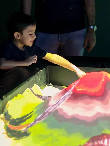 Building a volcano in the illusion sand pit. The red glow on top makes it look like it's about to erupt!
