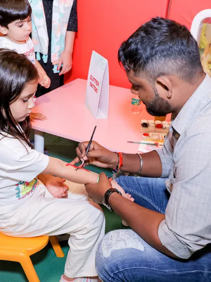 A young guest gets a glitter tattoo, one of our most popular party activities. Our artists create beautiful, sparkling designs that add a touch of magic to any celebration.