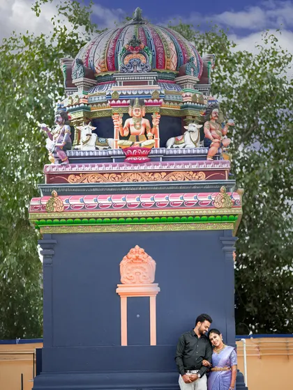 Incorporating local culture into a pre-wedding shoot, with the couple posing in front of a colorful temple gopuram in Palladam.