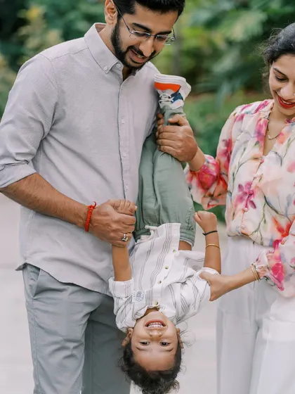A father holding his son upside down. The laughter and trust between them are wonderful to see.