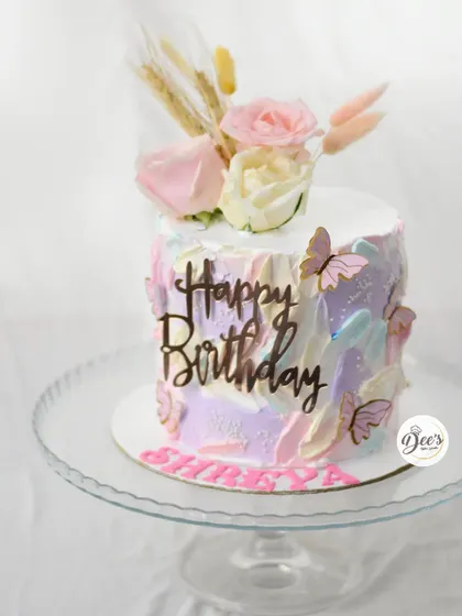 I love the soft, dreamy effect of this cake. The pastel watercolor buttercream is adorned with fresh flowers, dried grasses, and delicate butterflies for a beautiful, modern look.