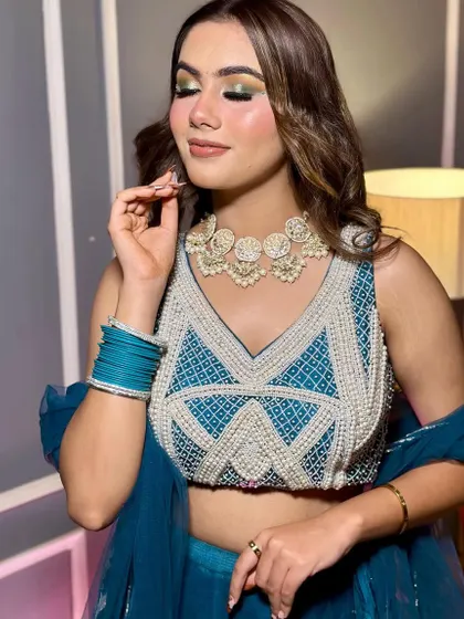 A vibrant and fresh look perfect for a sangeet or mehendi ceremony. I used a pop of green and gold on the eyes to match her teal lehenga, paired with soft waves and a dewy skin finish.