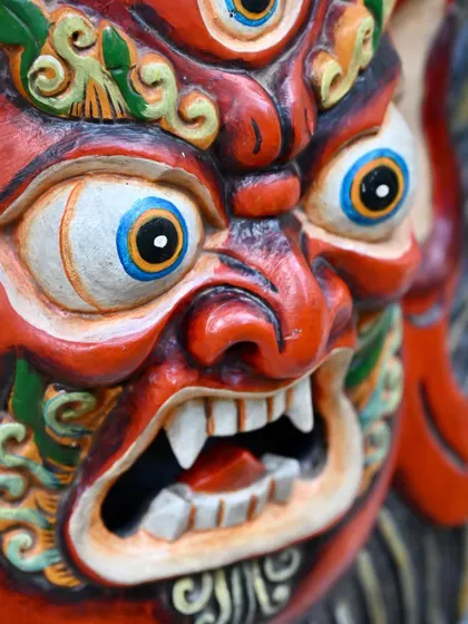 An extreme close-up of a Bhairava mask, showing the incredible detail in the hand-painted eyes and teeth. This is the level of emotion and character that Nepalese artisans carve into each piece.