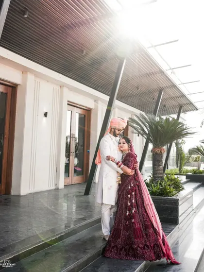 Using the bright sun to create a beautiful flare, we captured this portrait of the couple in a tender embrace outside their modern wedding venue.