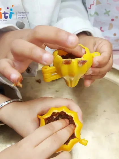 Tiny hands carefully press the date and nut mixture into a modak mold. This tactile activity is both fun and a great exercise for developing fine motor skills.
