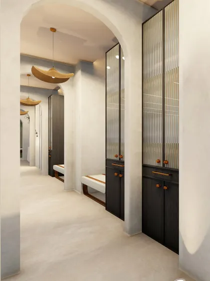 This view of the corridor shows the integration of functional elements like seating benches and storage lockers with fluted glass doors. The design ensures that even practical necessities contribute to the overall serene aesthetic.