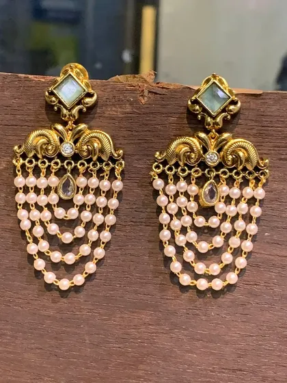 A pair of gold-look imitation earrings with a light-colored stone and delicate pearl drops. These are lightweight and perfect for wedding guests or festive gatherings.
