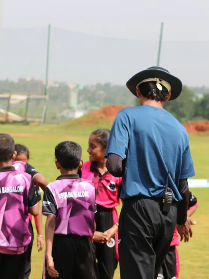 A coach interacting with young players during the RSCA Dasara Cup, providing guidance and encouragement.