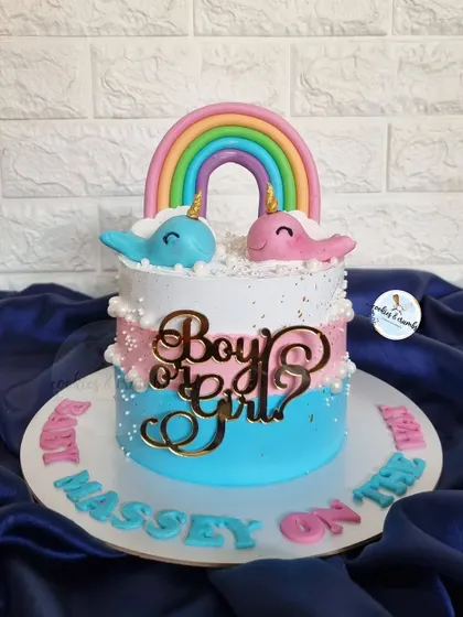 A cute gender reveal cake with two narwhals under a rainbow. The "Boy or Girl?" topper adds to the suspense and excitement of a baby shower.