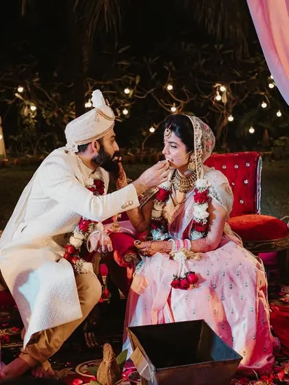 The couple shares a sweet, a traditional gesture of starting their new life with sweetness.