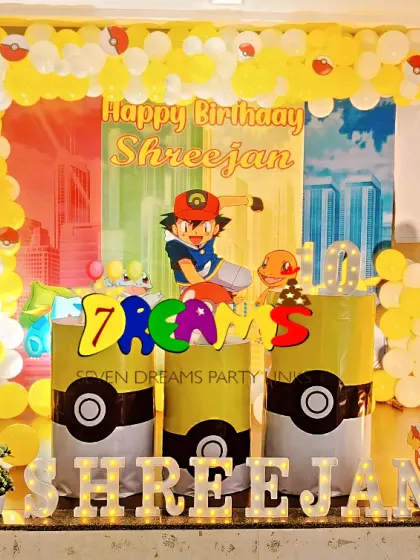 Gotta catch 'em all with this Pokemon themed party. This setup features a yellow balloon arch, a picket fence, and cutouts of Ash, Pikachu, and other popular Pokemon characters.